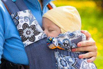 Newborn baby and mother outdoors walking with sling. - 86634463