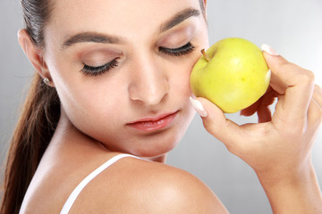 beautiful woman holding a fresh apple with eyes closed