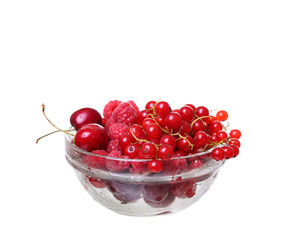 raspberries and currants cherries in a glass on white