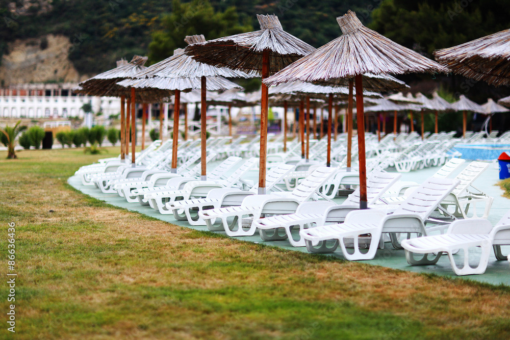 Wall mural Beach umbrellas at the hotel lounge chairs