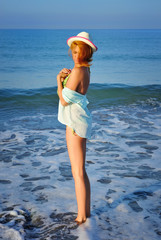 Young beautiful girl in the hat on the beach