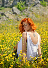 Beautiful young girl among yellow wildflowers