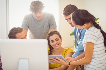 Creative business team gathered around a tablet