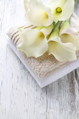 Obraz na płótnie Canvas Towels and bouquet of white calla flowers