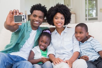 Happy family taking a selfie on the couch