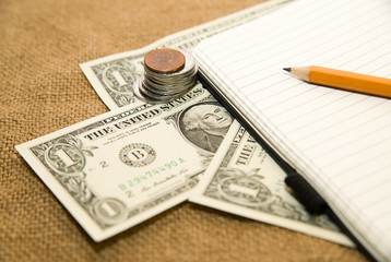 Opened notebook, pencil and money on the old tissue