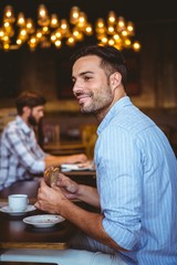 Smiling businessman holding a sandwich