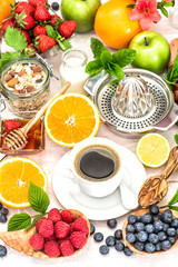 Breakfast table setting with coffee, croissants, granola, honey.