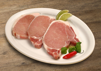 Raw meat selection on wooden cutting board with knife