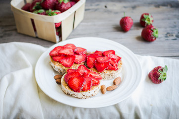 crispbread with peanut butter and fresh strawberries, rustic, he