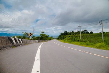 Winding Paved Road with cloud sky background