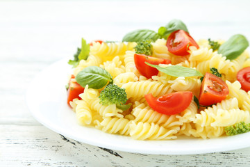 Delicious pasta on plate on white wooden background