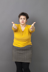 angry overweight young woman staring at someone with hands forward accusing and patronizing someone