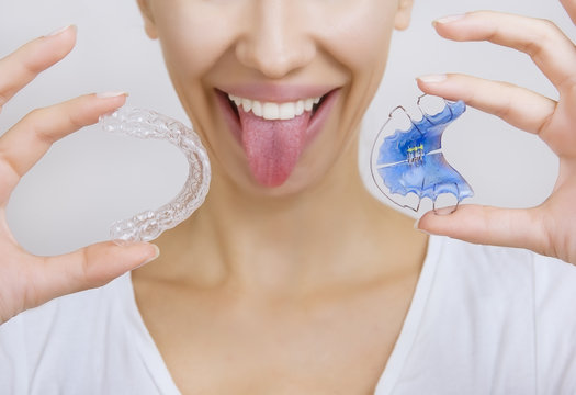 Smiling girl Holding Retainer for Teeth and Tooth Tray