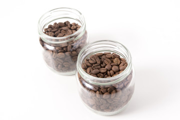 Obraz na płótnie Canvas Coffee beans in small glass jars isolated on white 