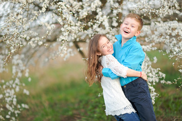 Fototapeta premium Portrait of a boy and girl in the lush garden