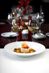 Shrimps on boiled rise in sauce, nicely served, glass of white wine in background, shallow depth of field
