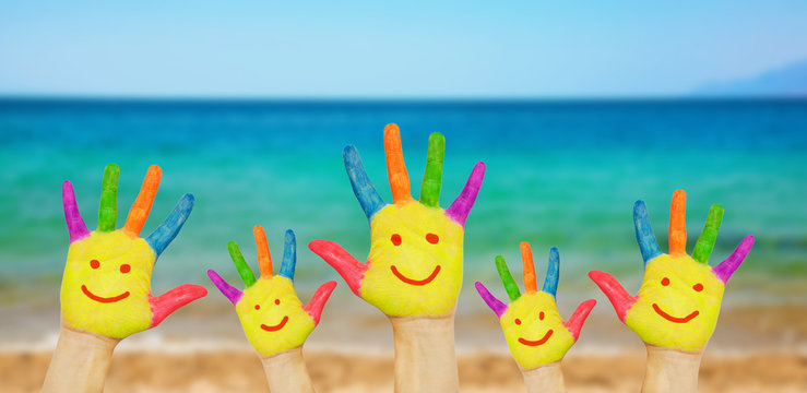 Children smiley hands on a beach