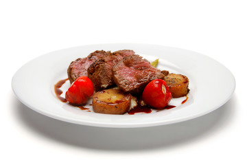 Raw steak with grilled potato and cherry tomato