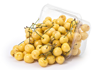 Box or punnet and spilled fresh ripe organic white cherries isolated on white background