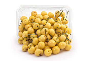Box or punnet and spilled fresh ripe organic white cherries isolated on white background