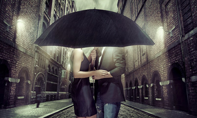 Young couple hiding themselves under the umbrella