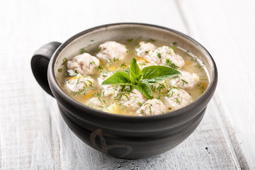 Soup with meatballs in ceramic bowl