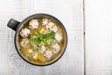 Soup with meatballs in ceramic bowl
