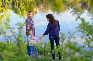 Fototapeta premium family dad mother and daughter on a walk on nature