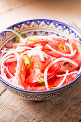 Pilaf and achichuk salad in handmade plate on wooden background