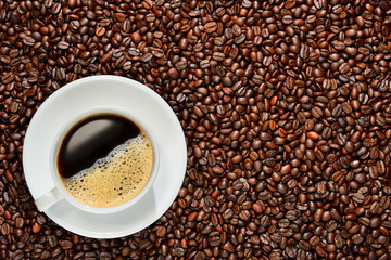 Cup of coffee on coffee beans background