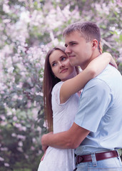 Portrait of beautiful young couple together in the flowering spr