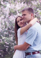 Fototapeta premium Portrait of beautiful young couple together in the flowering spr