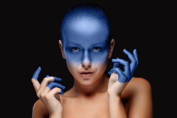 Naklejka premium Portrait of a woman who is posing covered with blue paint
