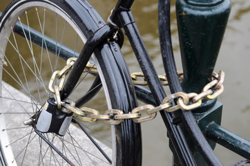 Fragment bike close-up metallic chain attached to railings in Am