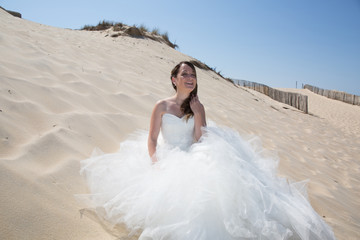 Fototapeta na wymiar Beautiful bride on the beach in wedding dress