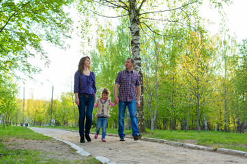 Obraz premium family dad mother and daughter on a walk on nature