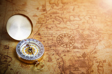Fototapeta na wymiar Retro compass on ancient world map, vintage style