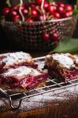 Homemade cherry pie covered in sugar with fresh cherries on top
