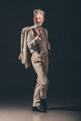 Bearded Man Holding his Coat with Legs Crossed
