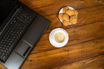 computer a cup of coffee and cookies