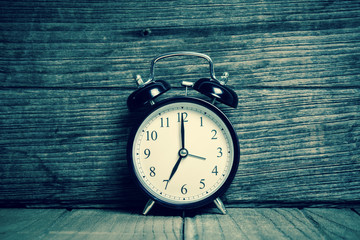Retro alarm clock with wood background  