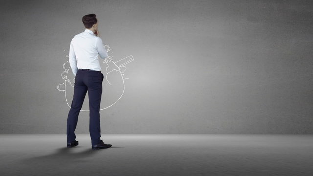 Businessman looking at grey wall with brainstorm