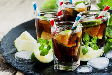 Cuba Libre with lime, mint and ice in a glass, selective focus