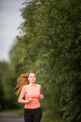 Young woman running outdoors on a lovely sunny winter/fall day 