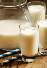 Jug of milk on old wooden table in rustic style, selective focus