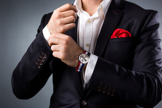 Man's style. Elegant young man getting ready. Dressing suit, shirt and cuffs
