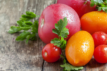 Assorted tomatoes: orange, pink, red cherry tomatoes with parsle