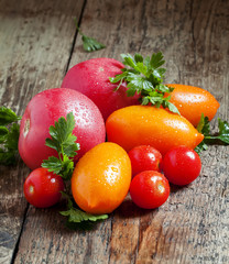 Assorted tomatoes: orange, pink, red cherry tomatoes with parsle