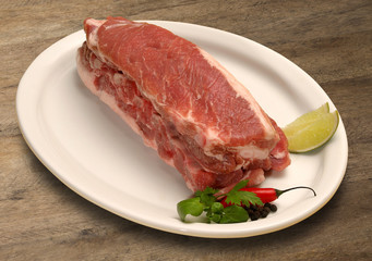 fresh raw pork chop with greens and spices.